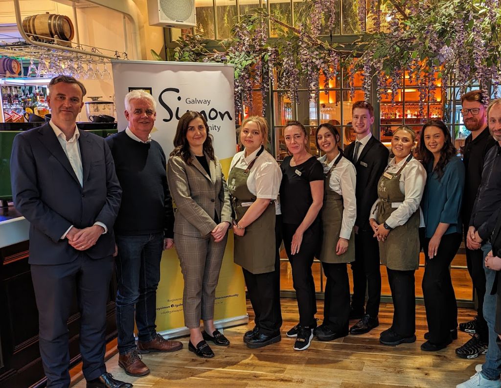 Team Supporting Galway Simon Community – A group of hospitality professionals, business leaders, and Galway Simon Community representatives pose together in a stylish venue, showing their support for the homelessness prevention initiative.